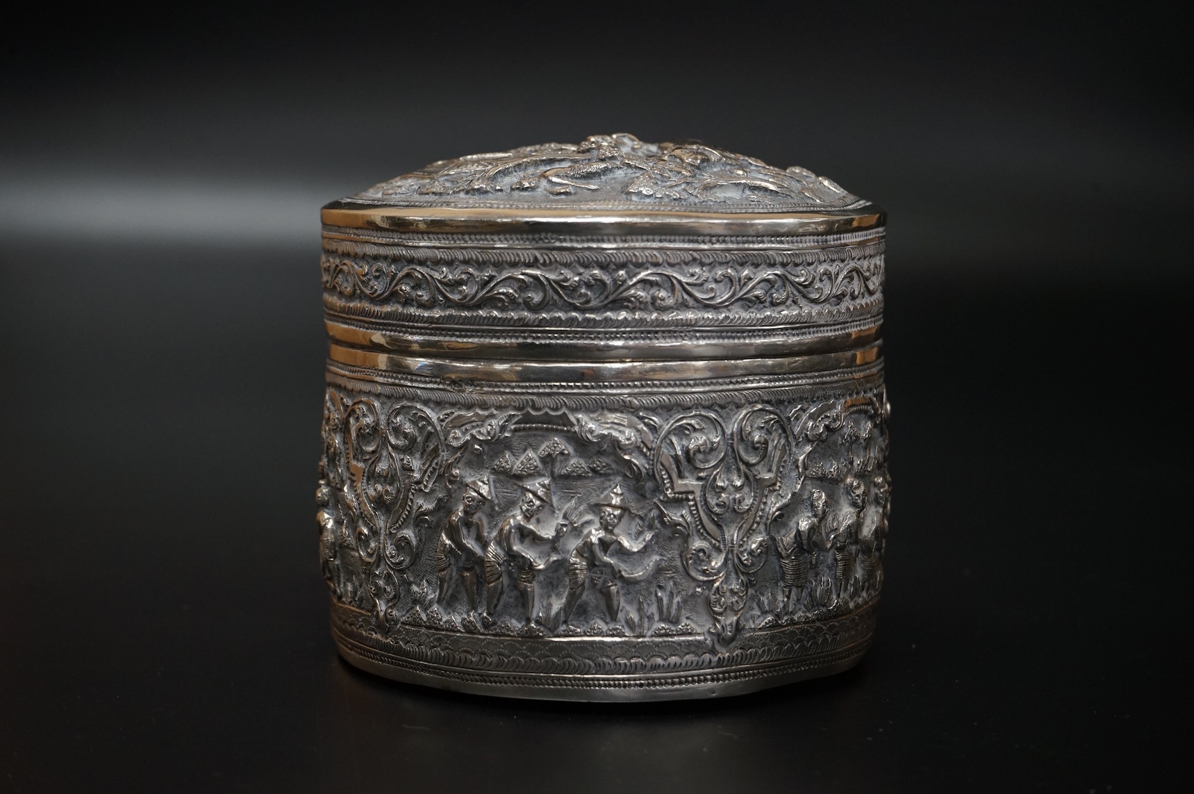 A Burmese embossed white metal circular bowl, signature to the base, diameter 11.4cm, together with a similar circular box and cover, 17oz.